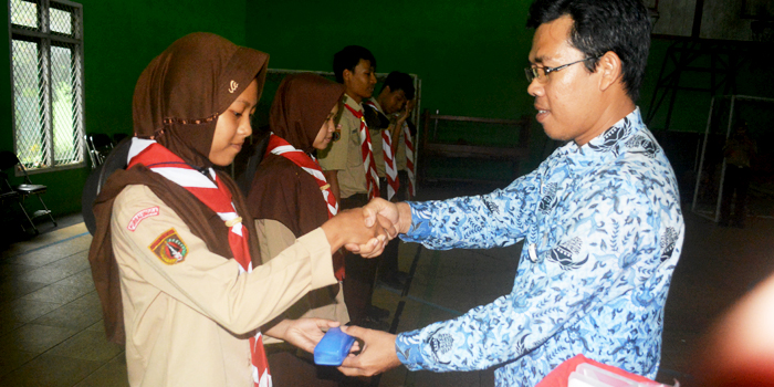 Kepala SMAN 1 Rembang, Purwito, S.Pd. (kiri) menyerahkan bantuan kacamata kepada peserta didik yang membutuhkan